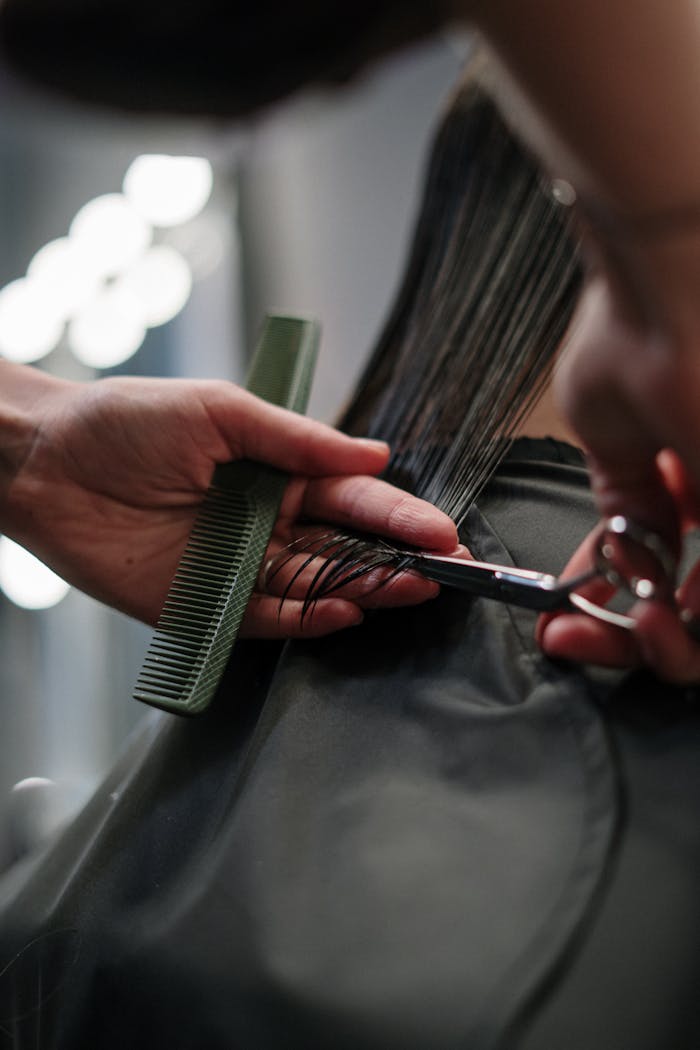project-02-c Close-up of hairstylist cutting wet hair in a salon.